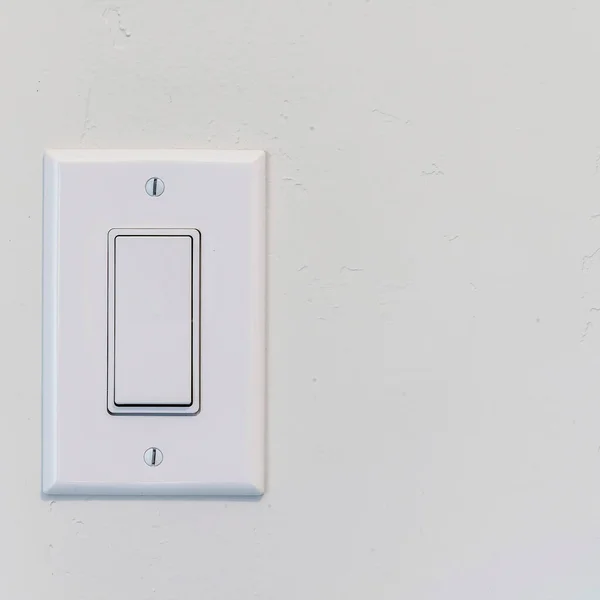 Square Electrical rocker light switch with flat broad lever on white interior wall — Stock Photo, Image