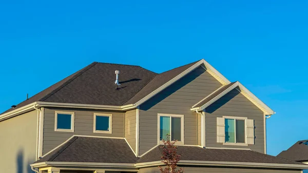Panorama frame Thuis exterieur met uitzicht op de bovenste verdieping tegen heldere blauwe lucht achtergrond — Stockfoto