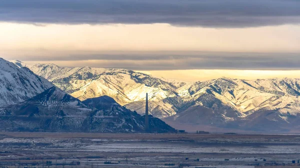 Panorama Vista panorámica de Salt Lake City bordeada por una imponente montaña nevada iluminada por el sol — Foto de Stock