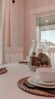 Masa takımı ve masa örtüsü ile dikey yemek masası bir süs eşyası etrafına dizilmiş.