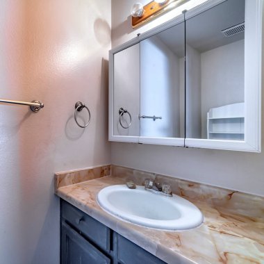 Kare hasatlı Oval lavabo mermer tezgahın üstünde, dolabı da evin banyosunda.