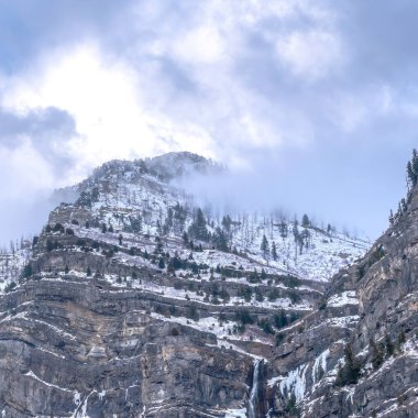 Dik ve engebeli yamaçlarıyla Provo Kanyonu 'nun üzerinde bulutlu, bulutlu, kare bir gökyüzü.
