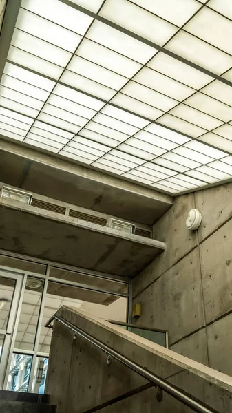 Vertical Indoor staircase of commercial building that leads to the balcony glass door