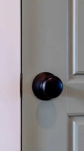 Rama pionowa Zamknięte szare drewniane drzwi z okrągłą czarną klamką wewnątrz domu — Zdjęcie stockowe