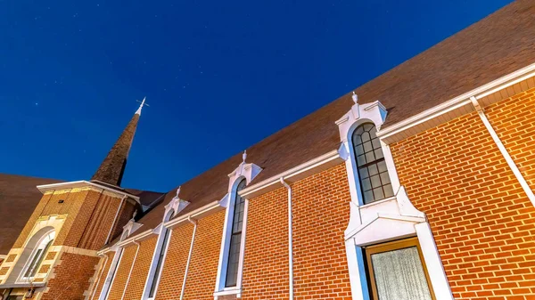 Panorama Cielo azul vivo sobre una iglesia en Provo Utah con pared de ladrillo y ventanas arqueadas — Foto de Stock