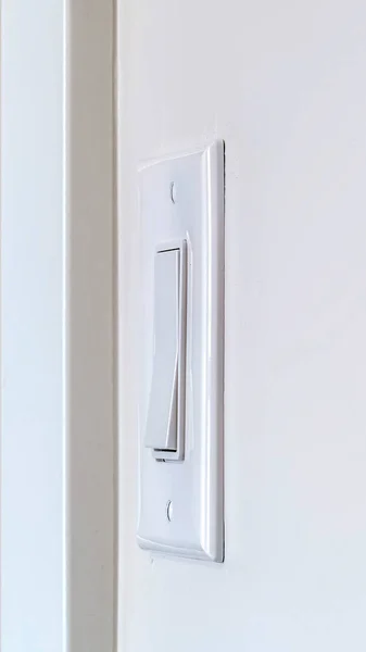 Vista lateral vertical del interruptor de luz basculante eléctrico montado en la pared interior blanca — Foto de Stock