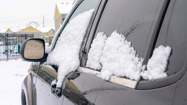 Panorama de la cosecha Vista exterior de un coche negro brillante con nieve fresca en las ventanas teñidas — Foto de Stock