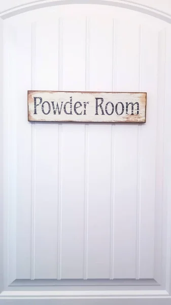 Vertical crop White panelled door with rustic rectangular wooden Powder Room sign