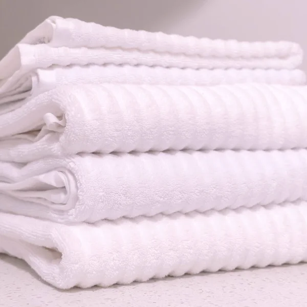 Square Folded white towels and ornamental indoor plant on the bathroom countertop — Stock Photo, Image