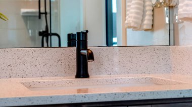 Panorama çerçeve. Evdeki banyonun içindeki beyaz tezgahın üzerinde siyah musluk olan lavabo.