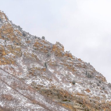 Utah 'taki Provo Kanyonu' nun kare kayalık dağ arazisi bulutlarla dolu arka planıyla