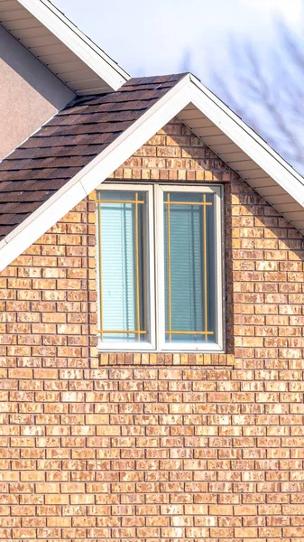 Vertikální rám Zblízka domácího exteriéru se sluncem osvětlenou střechou nad oknem a cihlovou zdí — Stock fotografie