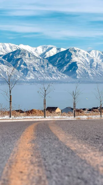 Cosecha vertical Snowy Wasatch Mountains y el azul Utah Lake con carretera en primer plano —  Fotos de Stock