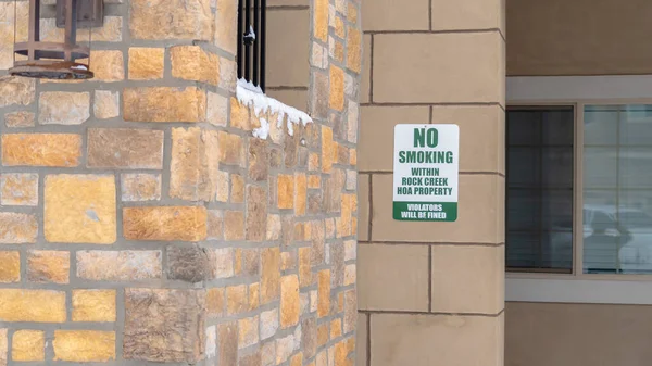 パノラマフレーム石レンガの壁に禁煙サイン付きアパートの外観 — ストック写真