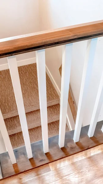 Vue verticale vers le bas sur escalier intérieur en forme de U avec balustre blanc et balustrade brune — Photo