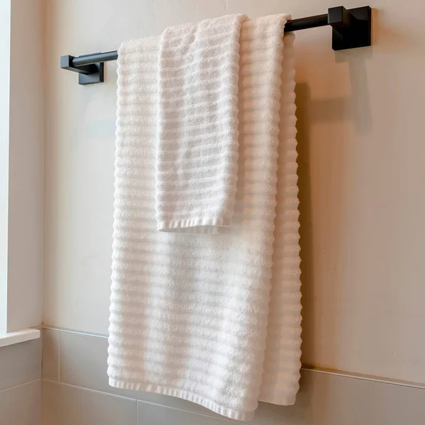 Varilla negra cuadrada con toalla blanca montada en la pared del baño con azulejos — Foto de Stock