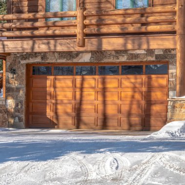 Park City Utah 'ta kışın karlı garaj yolu olan lüks bir ahşap evin ön cephesi