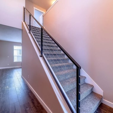 Kahverengi ahşap zemine ve sade beyaz ev duvarına karşı.