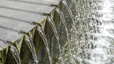 Panorama mahsulü. Yuvarlak taş havuz çeşmesini parlak berrak suyla kapat.