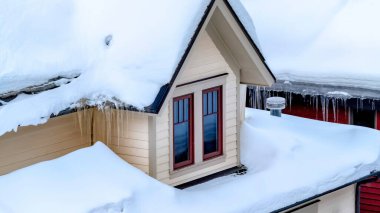 Panorama çerçevesi Park City Utah 'ın evini sarkıtlar ve çatıda kalın kar tabakalarıyla kapatın