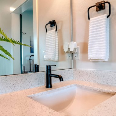 Kare çerçeve banyo lavabo ve musluk asılı havlu soketi ve lamba anahtarı ile duvara karşı