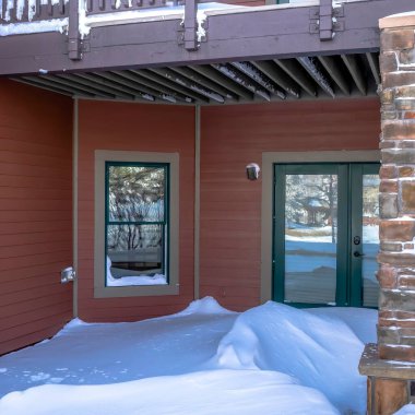 Çift cam kapılar ve karlı giriş üzerinde balkon ile kare çerçeveli ev cephesi