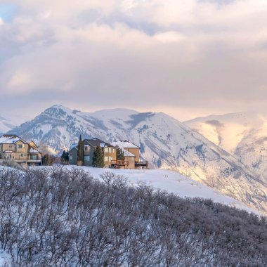 Kare çerçeveli Picturesque Wasatch Dağları kışın karlı bir ortamda evleri olan