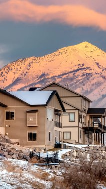 Yaban Arısı Dağları manzaralı tepedeki dikey ekin evleri ve gün batımında bulutlu gökyüzü