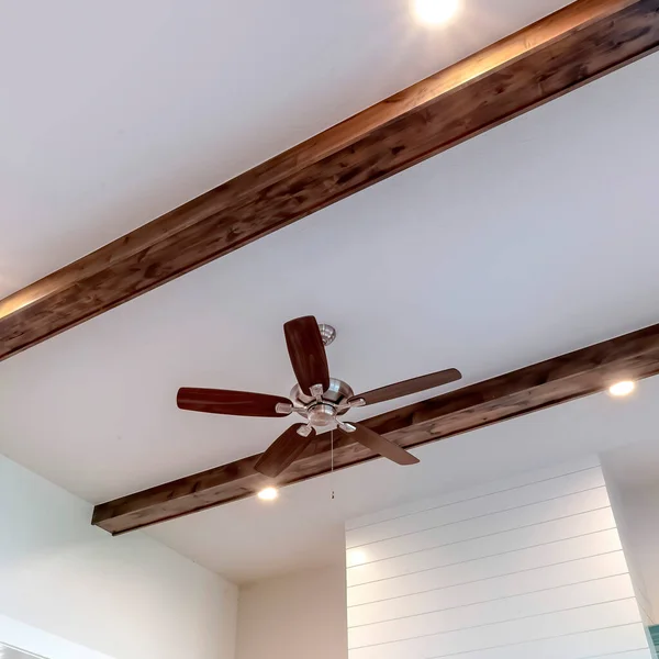 stock image Square crop Wood beams and recessed bulbs with ceiling fan and lights at the center