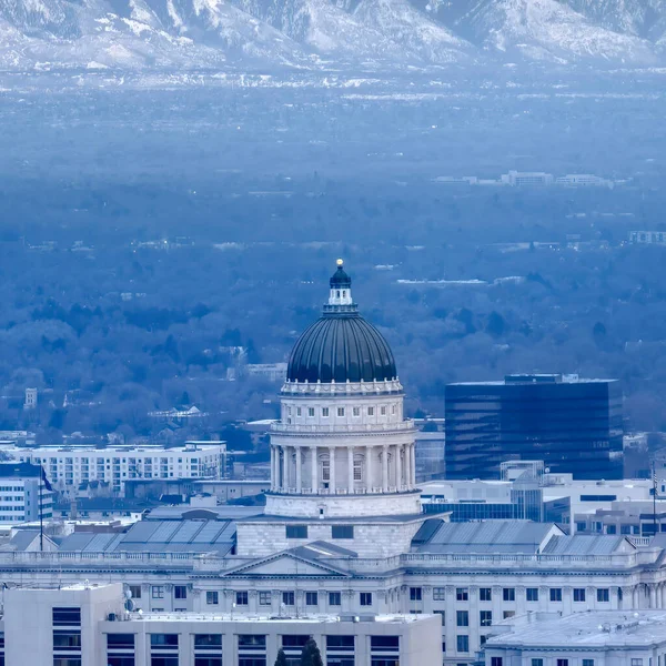 Square crop Utah State Capital Building against steep snowy mountain and gray cloudy sky — Stock Photo, Image
