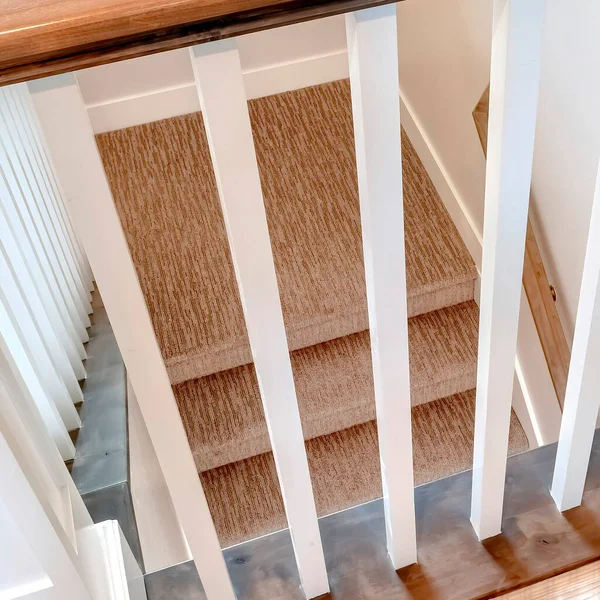 Cadre carré Vue vers le bas sur escalier intérieur en forme de U avec balustre blanc et main courante brune — Photo