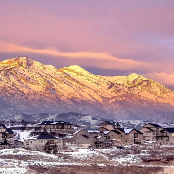 Casas cuadradas en la colina nevada contra la escarcha Wasatch Mountain con brillo dorado al atardecer — Foto de Stock