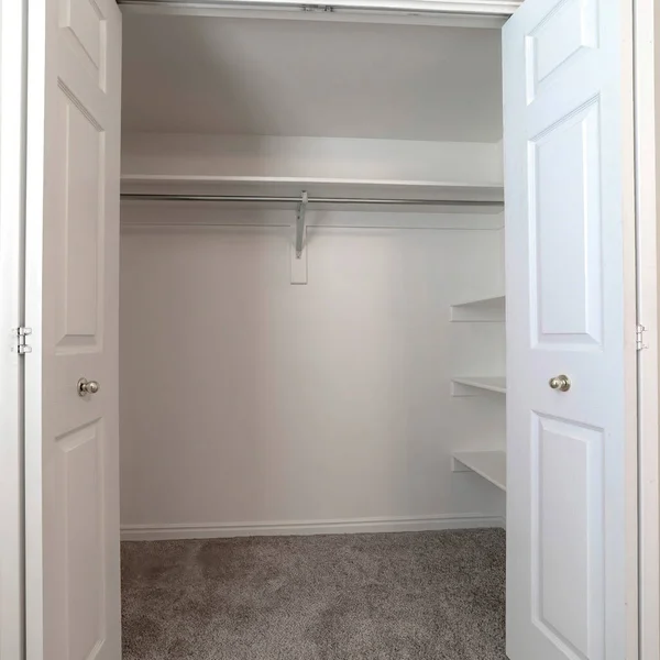 Cosecha cuadrada Walk in closet con puertas de doble bisagra lisa pared blanca y alfombra de piso gris — Foto de Stock