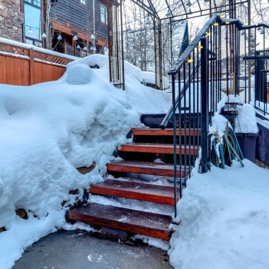 Kışın karlı yamaçlara karşı tırabzanlar üzerinde sicim ışıkları olan meydan dış merdivenleri.