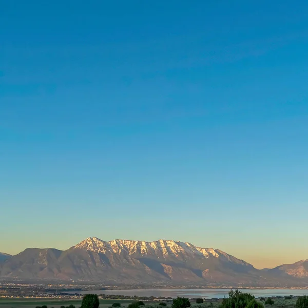 Carré Ciel bleu vif sur la neige plafonné montagne et lac sur un paysage naturel pittoresque — Photo