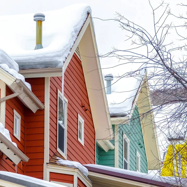 Casas Quadradas exterior com telhados nevados e paredes coloridas contra colina e céu — Fotografia de Stock