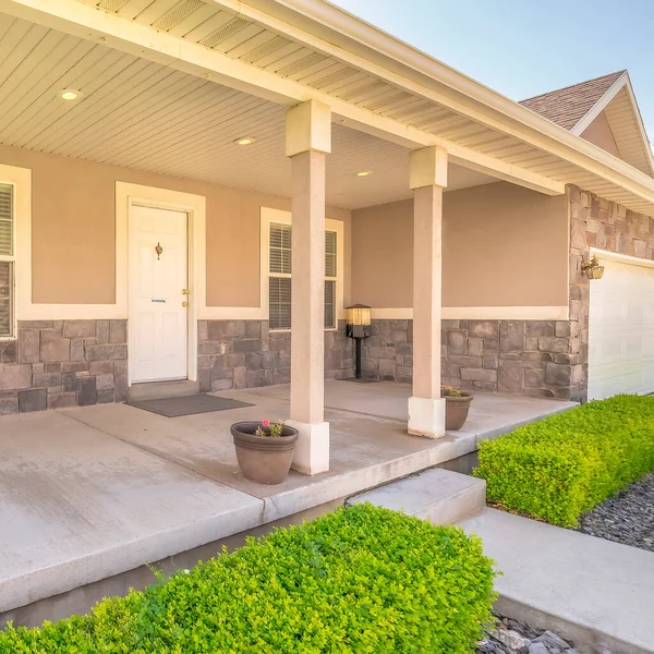 Square Home facade with concrete porch and white front door flanked by windows — Stock Photo, Image