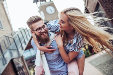 Genç şık mutlu çift zaman açık havada birlikte geçiriyor. Çekici kadın ve yakışıklı sakallı adam eğlenceli birlikte şehirde yaşıyorsanız.