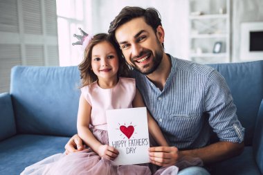 Seni seviyorum, baba! Yakışıklı genç adam evde küçük sevimli kızı. Mutlu babalar günü!