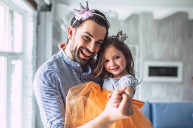 Seni seviyorum, baba! Yakışıklı genç adam evde etek giyen küçük şirin kızı ile dans ediyor. Mutlu babalar günü!