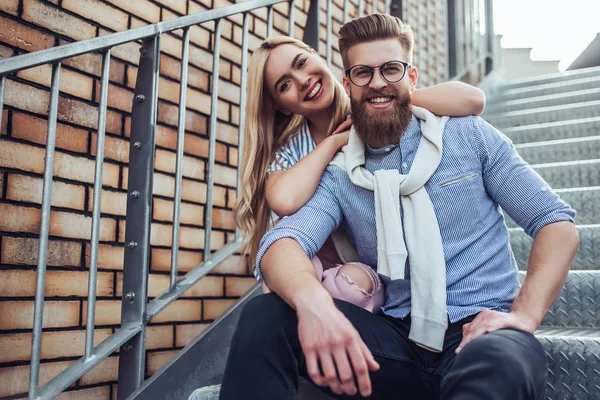 年轻时髦的快乐情侣在户外花时间 迷人的女人和英俊的胡子男子坐在楼梯上的城市 — 图库照片