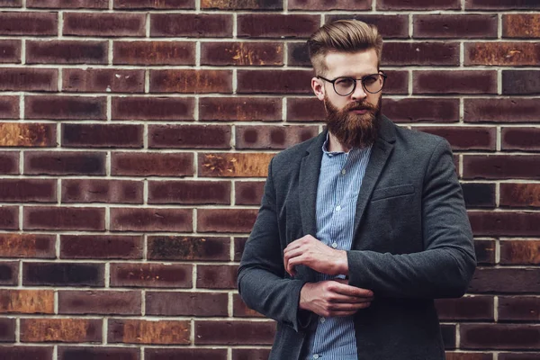 Homem Barbudo Elegante Está Posando Fundo Tijolo Cidade Jovem Óculos — Fotografia de Stock