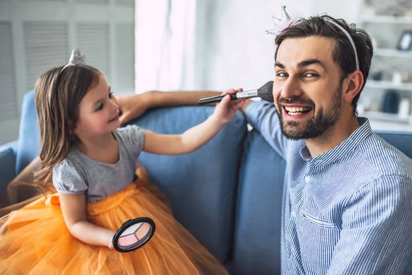 Seni seviyorum baba! Evdeki yakışıklı genç adam ve küçük tatlı kızı. Kızı, babası için makyaj yapıyor. Babalar Günün kutlu olsun.!