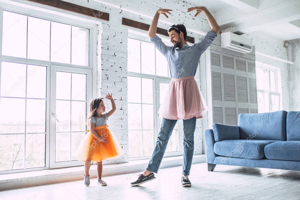 I love you, dad! Handsome young man at home is dancing with his little cute girl wearing skirt. Happy Father's Day!
