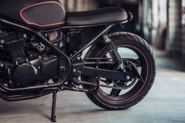 Modern siyah motosiklet garajda görüntü kesilmiş. Cafe racer.