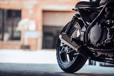 Modern siyah motosiklet garajda görüntü kesilmiş. Cafe racer.