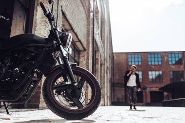 Klasik tarzı siyah motosiklet ile yakışıklı sakallı motorcu. Cafe racer.