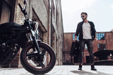 Klasik tarzı siyah motosiklet ile yakışıklı sakallı motorcu. Cafe racer.