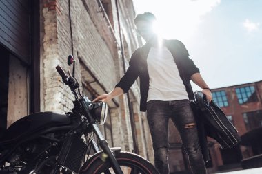 Klasik tarzı siyah motosiklet ile yakışıklı sakallı motorcu. Cafe racer.