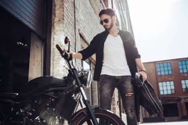 Klasik tarzı siyah motosiklet ile yakışıklı sakallı motorcu. Cafe racer.
